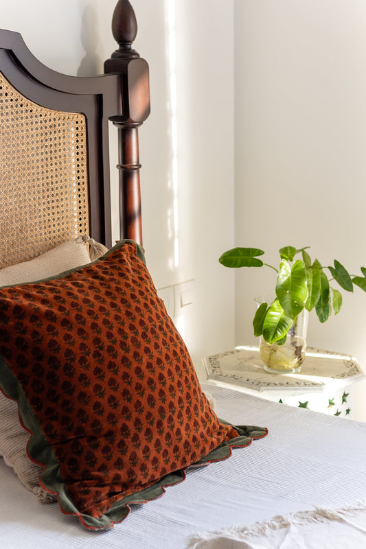 Scalloped Edge Block Print Cushion Cover on rattan bed with plant in the background