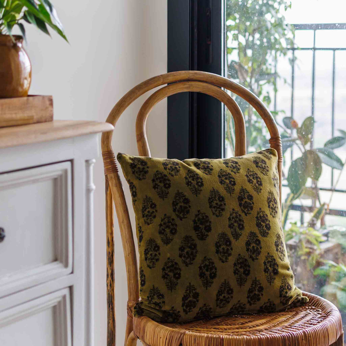 Block print cushion cover in Olive green colour on soft velvet cotton on a chair