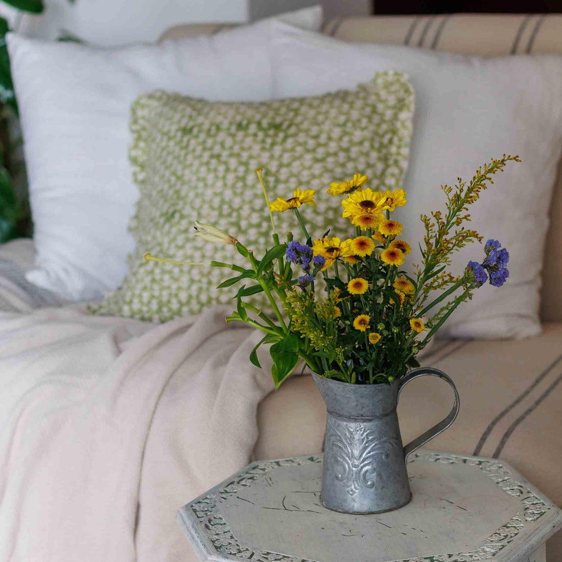 Cozy reading nook with pillows, throws and flowers 