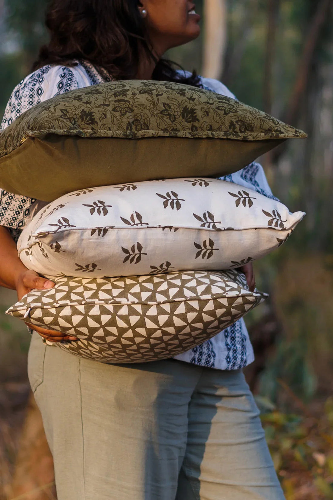 A woman carrying 3 Block Print Cushion Covers