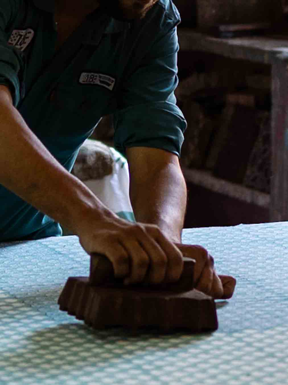 Artisan stamping fabric with wooden blocks