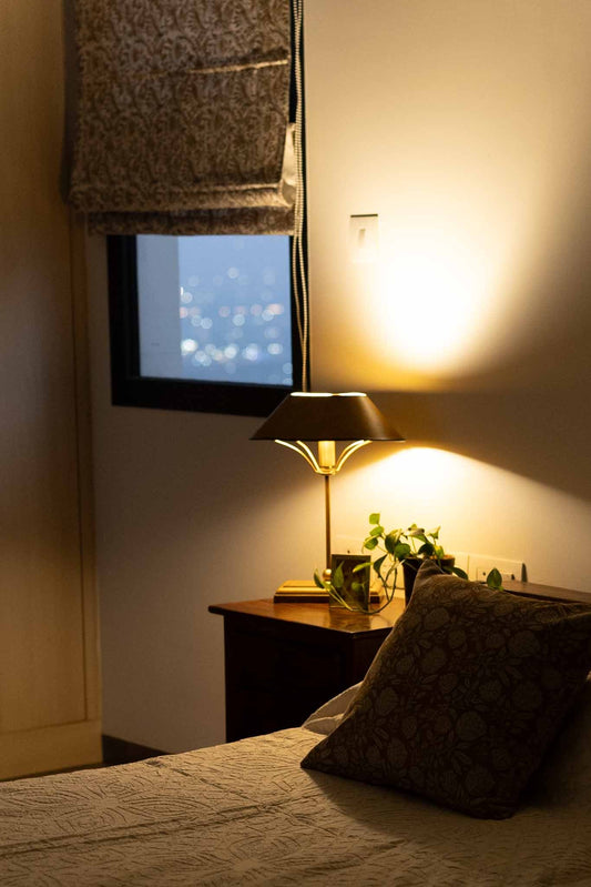 A warm Table lamp next to a bed for Diwali 