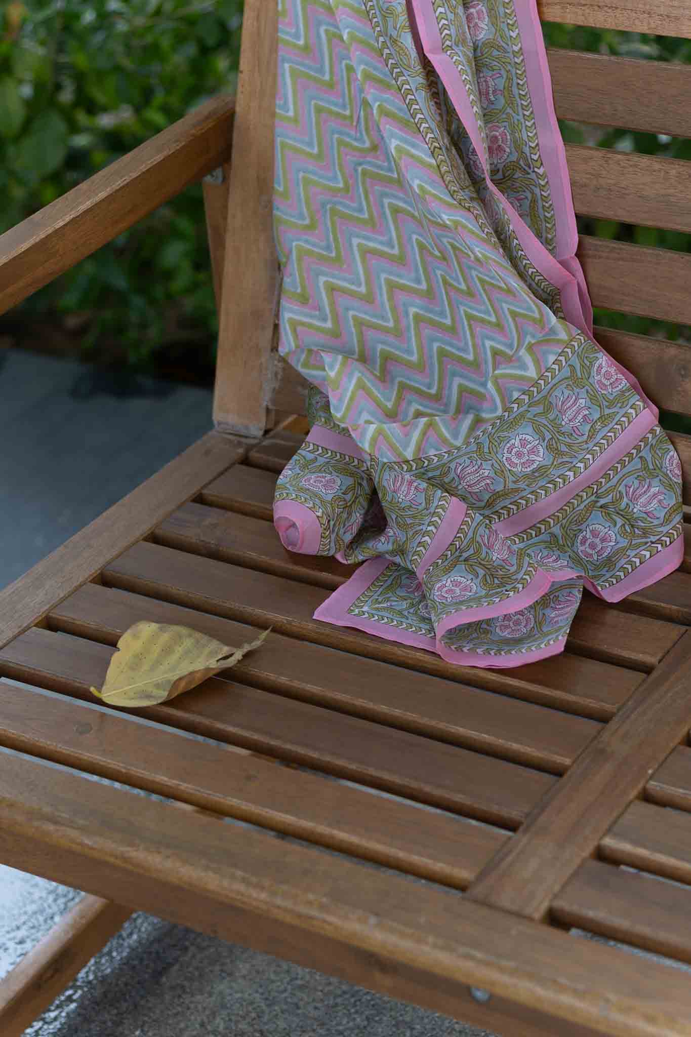 Block Print Patterned silk scarf draped over a wooden chair with a garden background