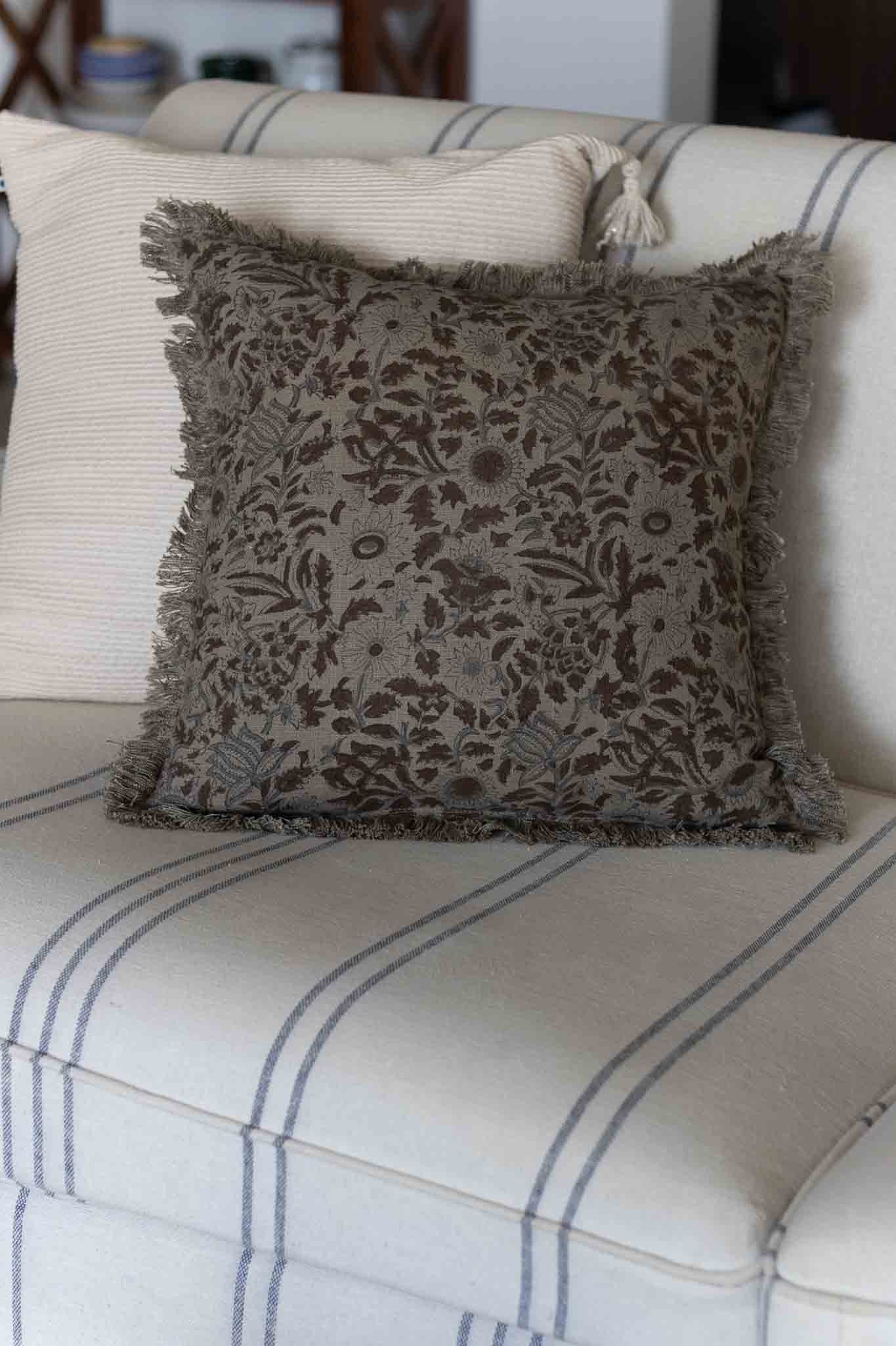 Decorative pillow with floral pattern on a striped sofa