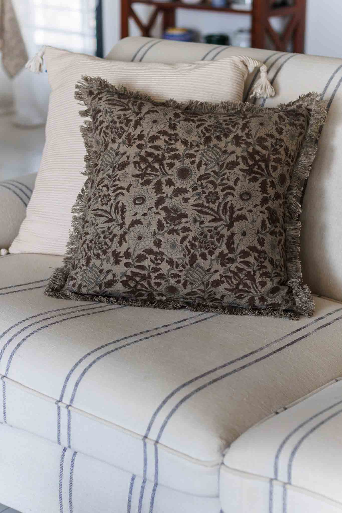 Decorative pillow with floral pattern on a striped sofa