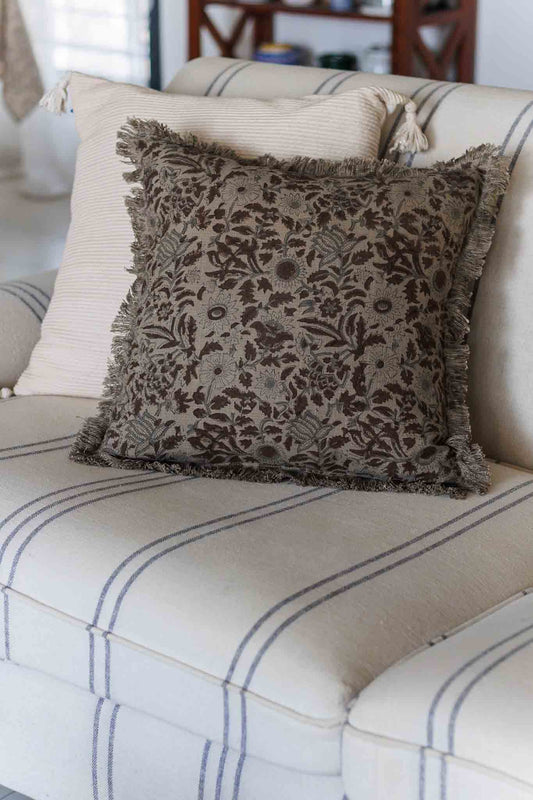 Decorative pillow with floral pattern on a striped sofa