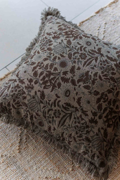 Decorative pillow with floral pattern on a textured surface