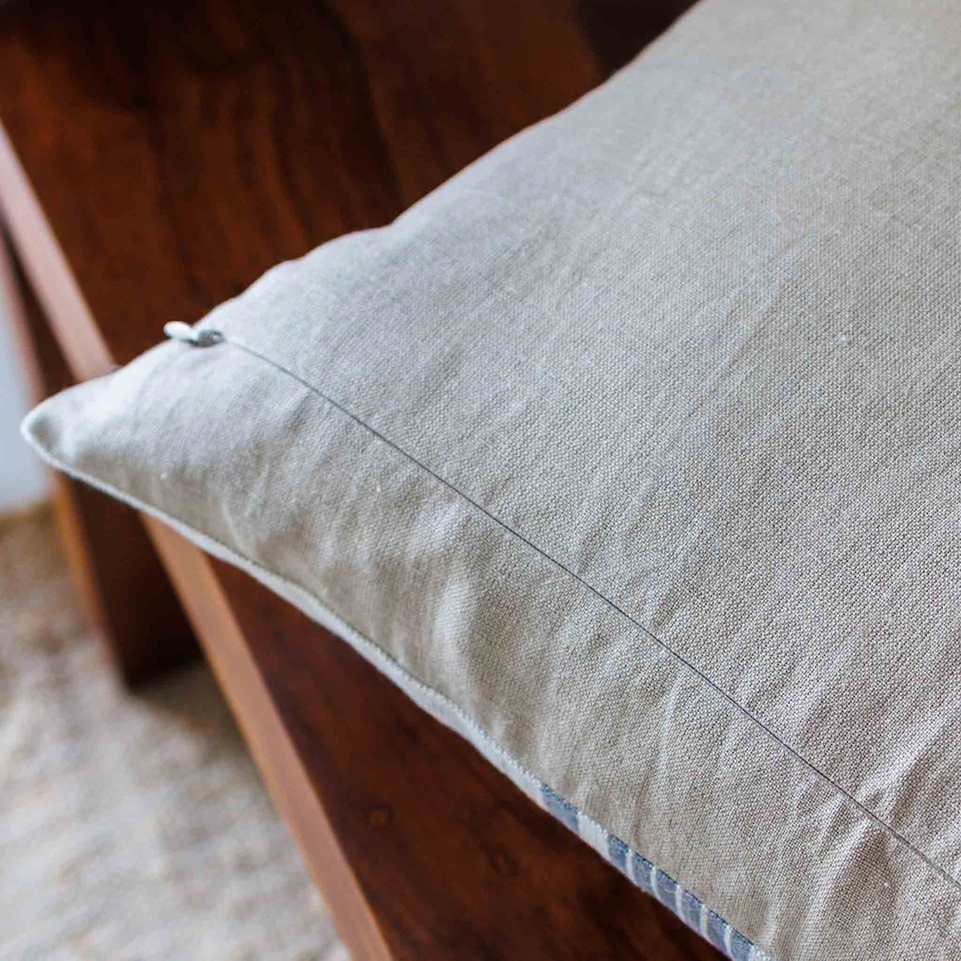 Textured beige pillow on a wooden surface