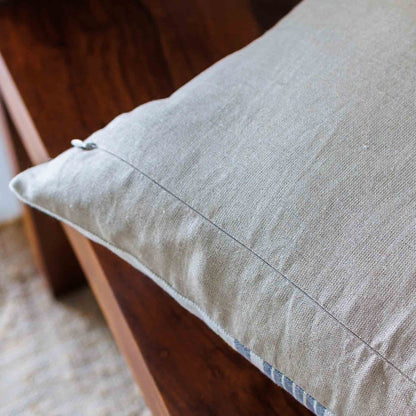 Textured beige pillow on a wooden surface