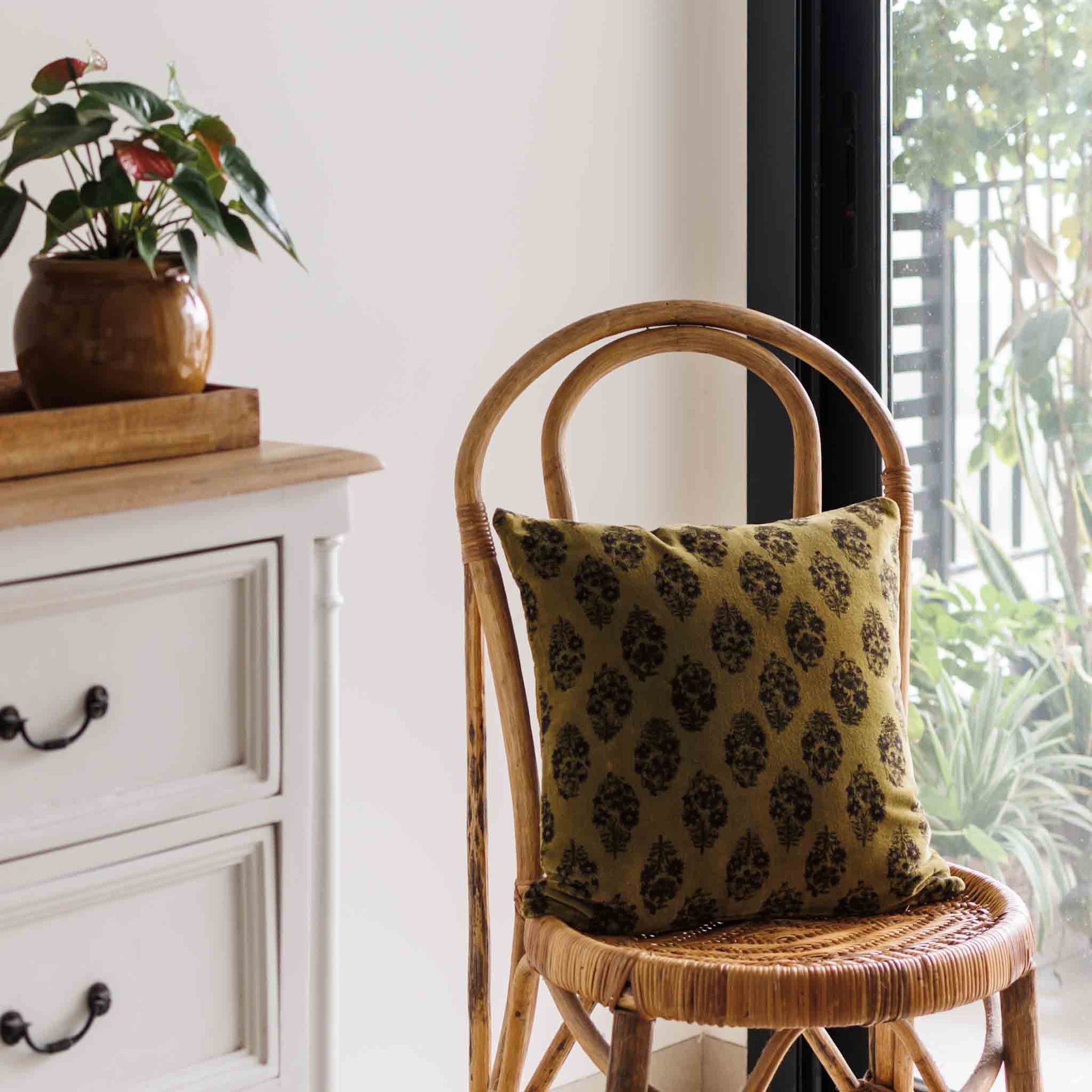 Block print cushion cover in Olive green colour on soft velvet cotton on a chair 