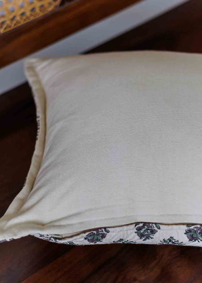 A close-up of a cream-colored pillowcase with a floral patterned border.