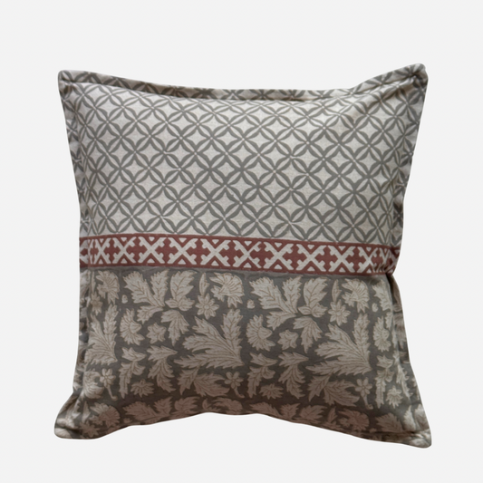 A cotton cushion cover with a three-section patterned design: top with a grey geometric lattice pattern, a middle band with a red  geometric motif, and a bottom floral grey damask pattern.