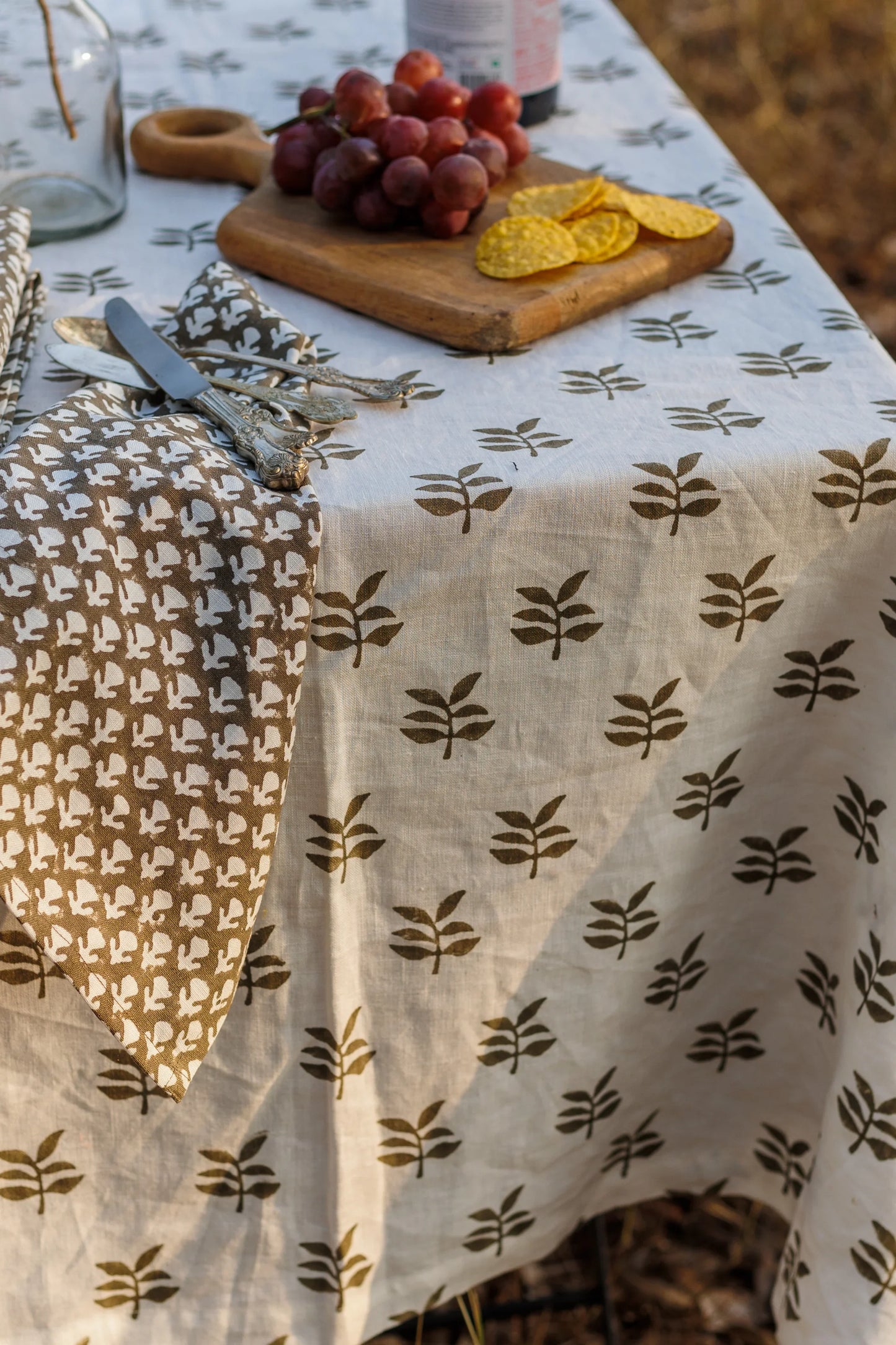 White Linen Tablecloth with leaf pattern on a table with fruits and cutlery