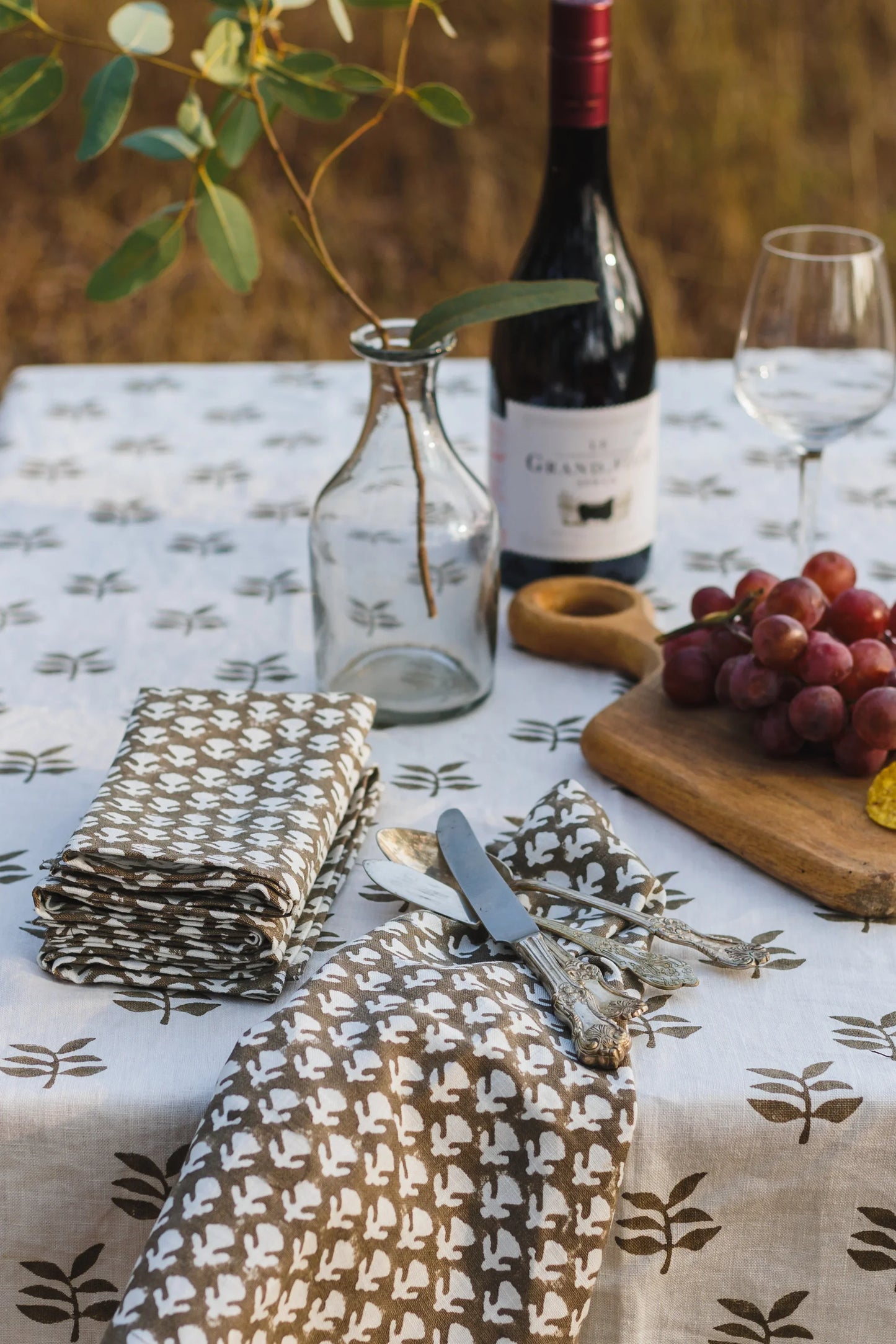 Table setting with wine, glasses, and patterned tablecloth