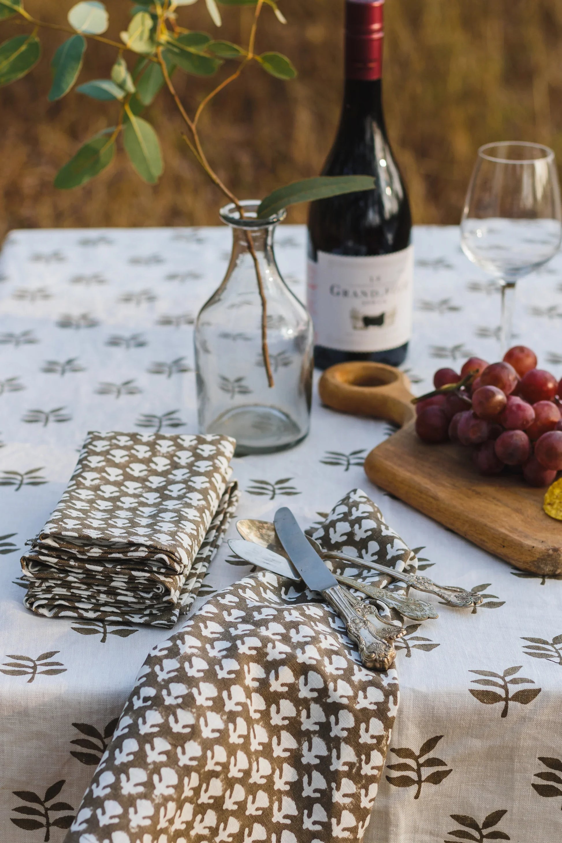 Table setting with wine, glasses, and patterned tablecloth