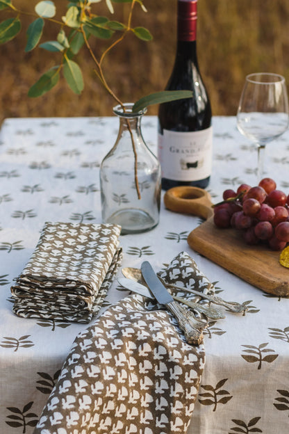 Table setting with wine, glasses, and patterned tablecloth