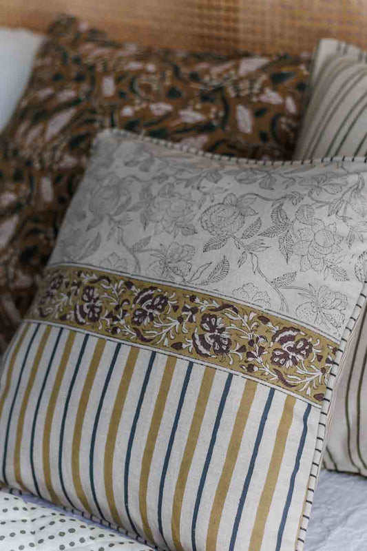 Floral and stripe patterned cushion covers on cane bed