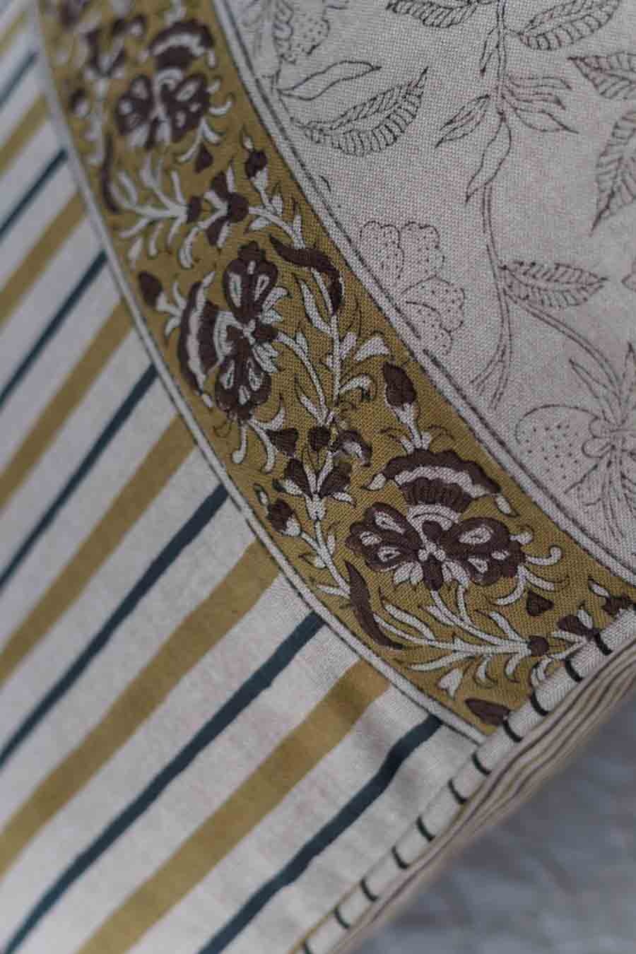Close-up of a floral patterned cushion cover showing a cream base with dark navy vertical stripes.