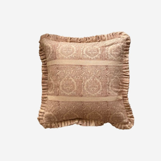 A square decorative cushion with a ruffled edge, featuring a woven damask pattern in warm beige and brown tones, isolated on a light gray background