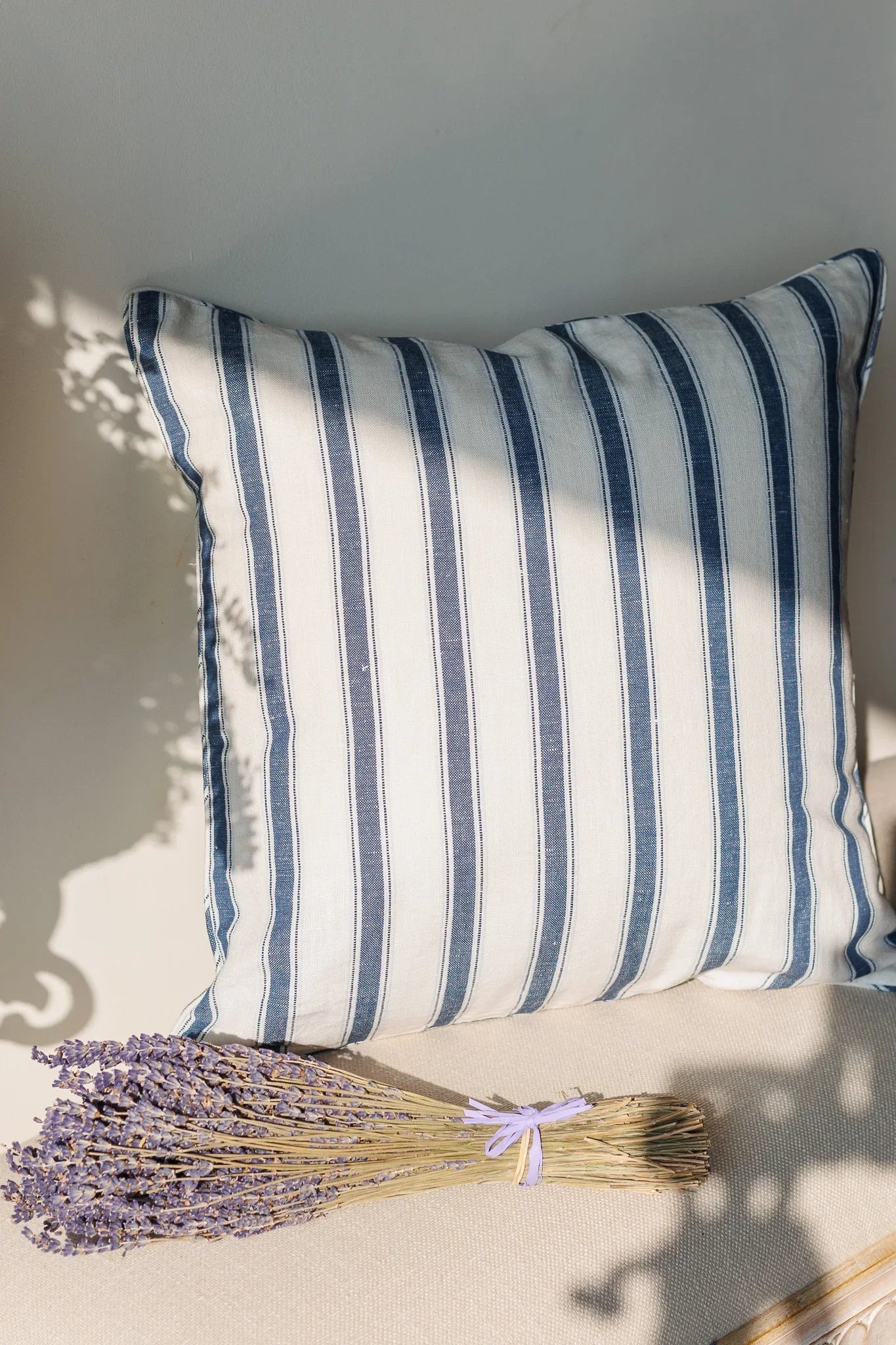 Blue and white Striped linen pillow with lavender on a neutral background