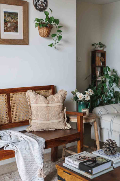 Cozy living room with block print cushion cover on wooden bench, and books on a coffee table.