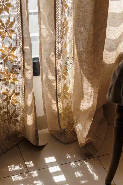 beige lace curtains close up with sunlight streaming through